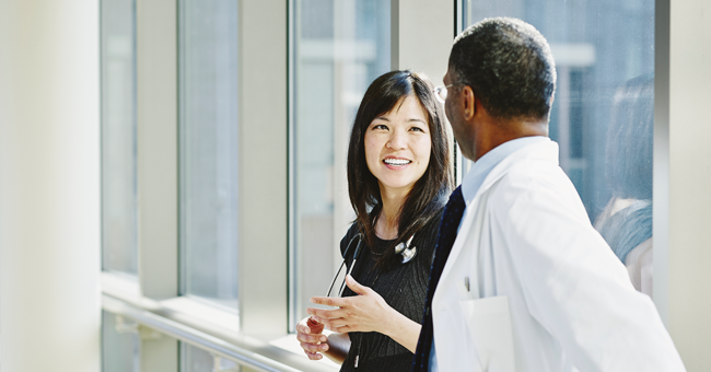 two medical professionals having a conversation in hallway